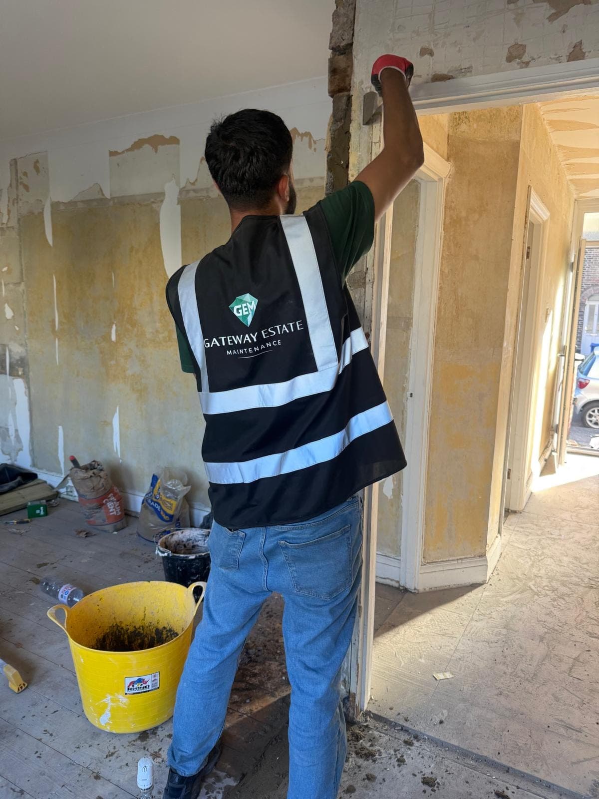 GEM operative in hi-vis stripping walls back for redecoration between tenancies